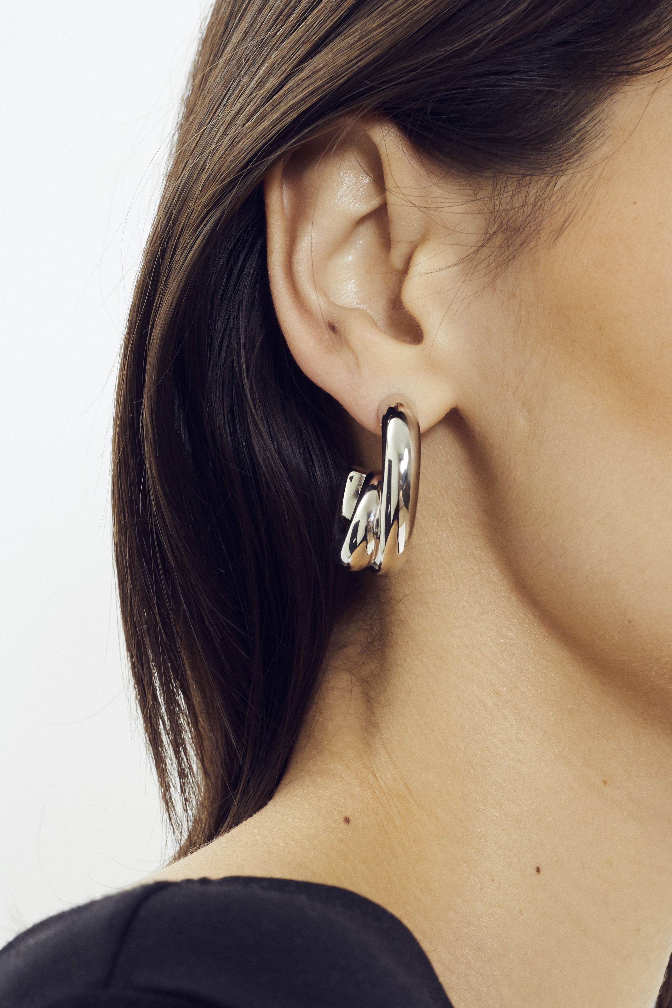 Sculptural hoop earring in platinum finish by SONNEY, shaped like a coiled tube