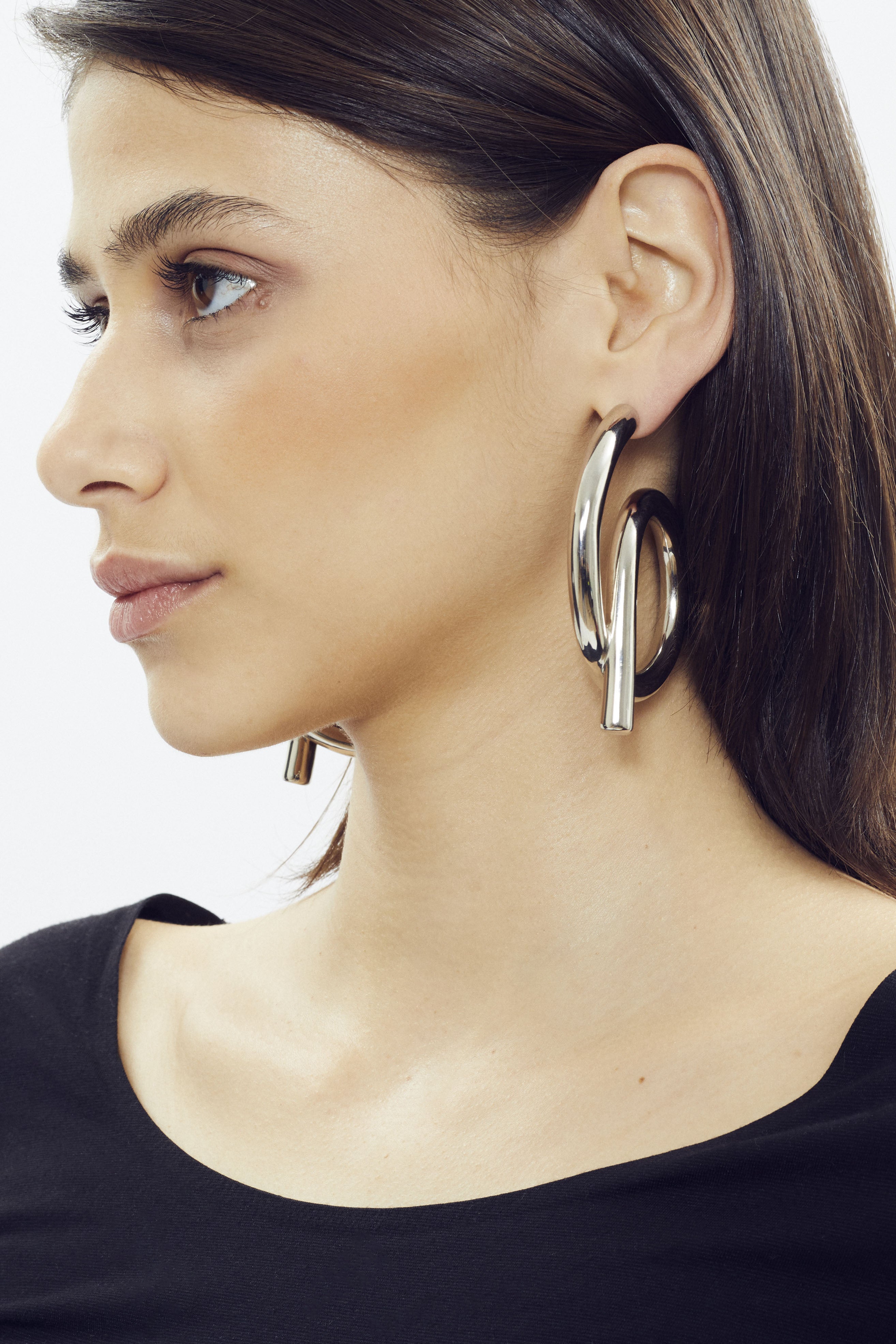 Large sculptural hoop earring with platinum finish by SONNEY, twisted tube shape