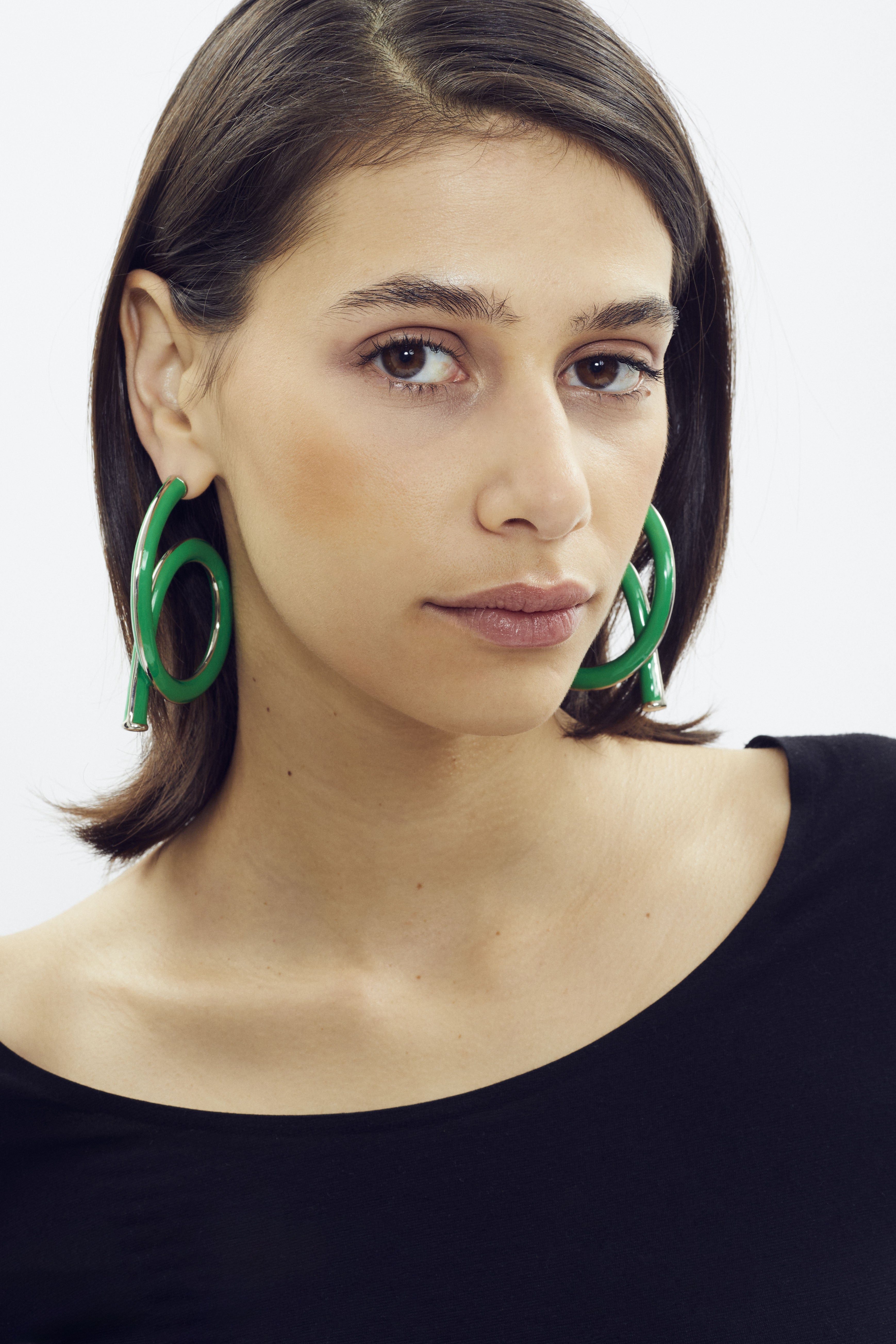 Large green enameled hoop earring by SONNEY, platinum finish, coiled tube inspired